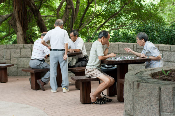 Дедушки в Кулун парке. Большая часть жизни местных пенсионеров уходит на игру в шахматы. Для этого в парках предусмотрены специальные столики