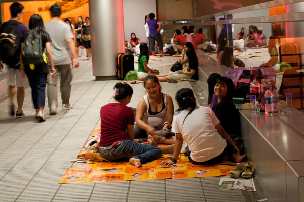 Филиппинские домработницы играют в карты в переходе к торговому центру IFC
