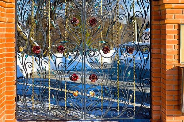 Резные ворота украшены чудесными коваными цветами